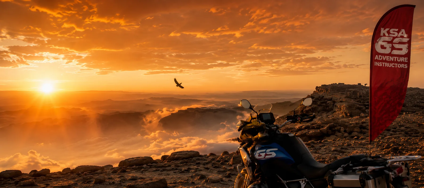 BMW GS on a dramatic Saudi mountain sunrise with KSA GS Adventure flag